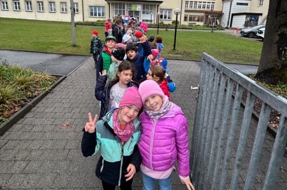 Schulkinder machen sich bereit für den Spaziergang zum Umwelttheater stehen vor dem Schulhaus