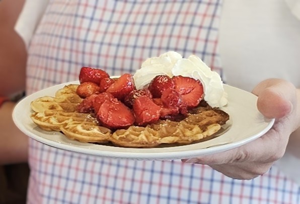 Frische Waffeln mit Erdbeeren und Sahne.